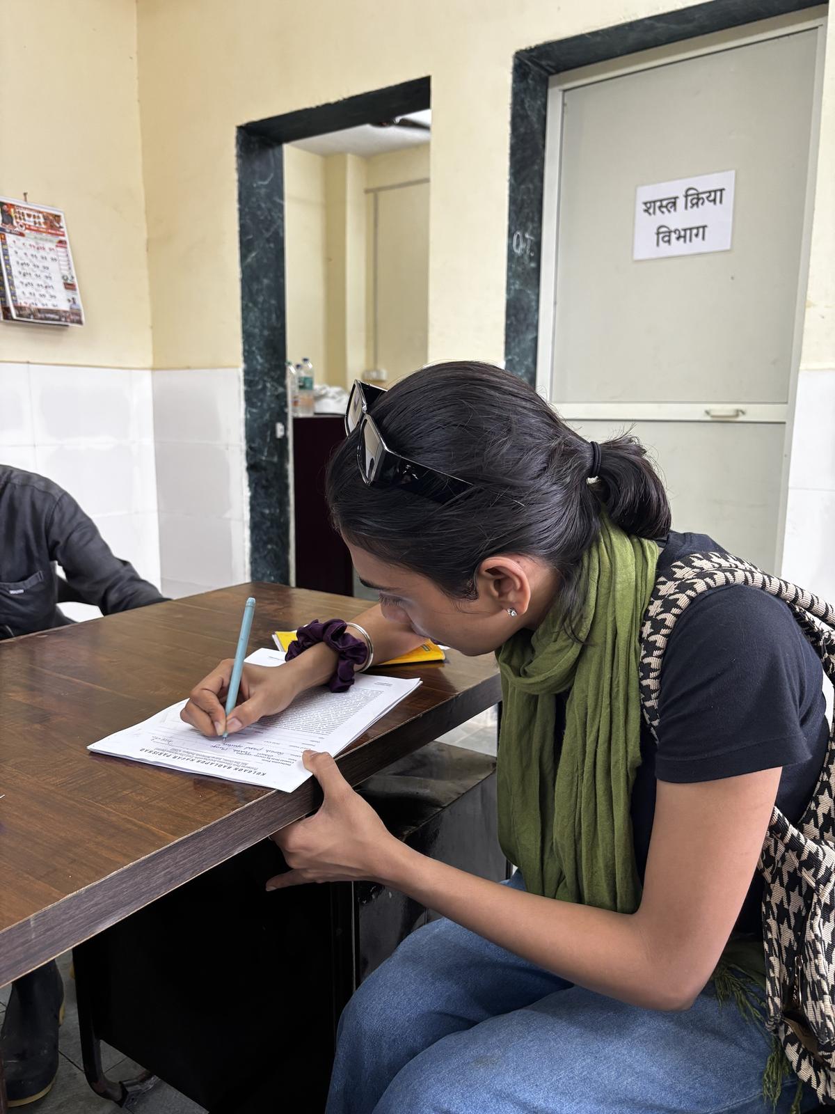 Volunteer completing paperwork outside a surgery room